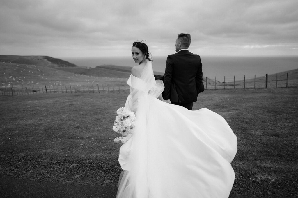 auckland bride wearing trish peng wedding dress walking in the field