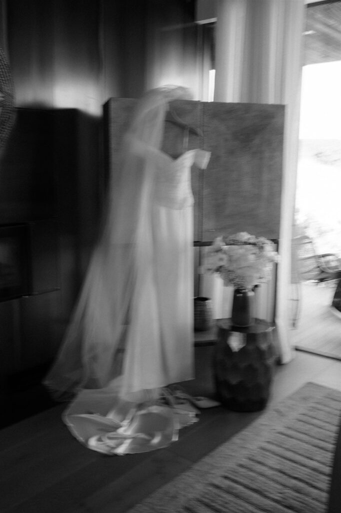 photo of vinka design gown hanging as bride gets ready in the morning